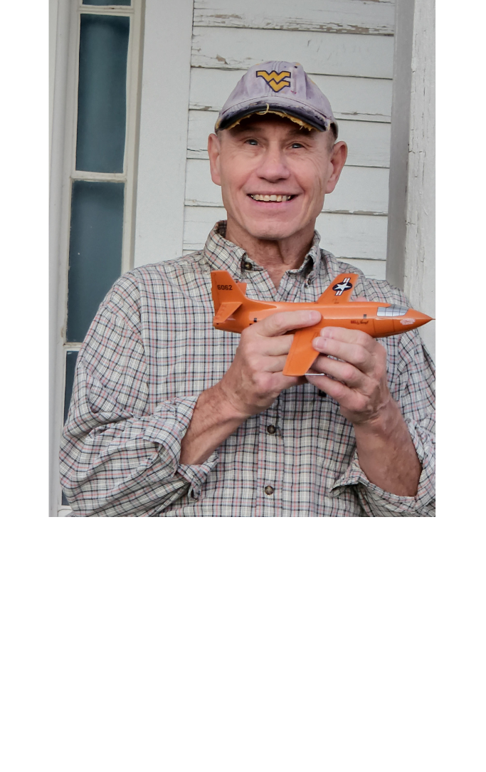 Man in a hat holding a airplane model in his hands