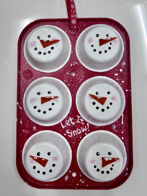 Muffin pan painted with snowmen faces